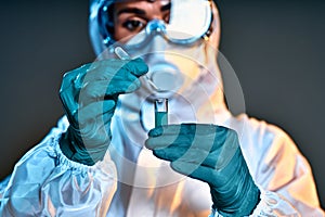 The doctor or lab technician scientist in PPE Personal Protective Equipment holding vacine test, Vaccine injection, World