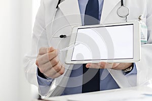 Doctor in labcoat showing digital tablet at hospital