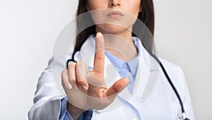 Doctor Lady Touching Invisible Medical Touchscreen Standing, Studio Shot, Cropped