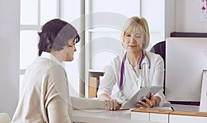 Doctor with laptop and pregnant woman in doctor`s office