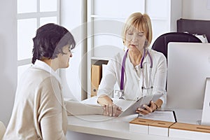 Doctor with laptop and pregnant woman in doctor`s office