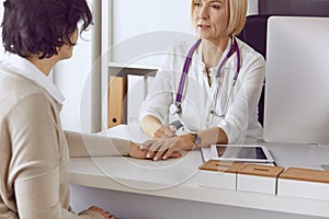 Doctor with laptop and pregnant woman in doctor`s office