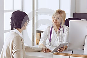 Doctor with laptop and pregnant woman in doctor`s office