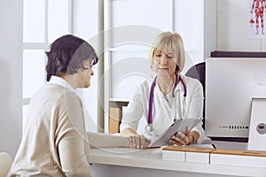 Doctor with laptop and pregnant woman in doctor`s office