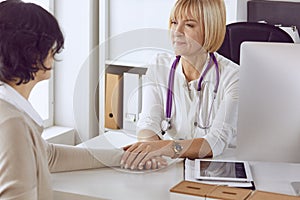 Doctor with laptop and pregnant woman in doctor`s office