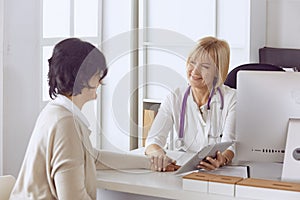 Doctor with laptop and pregnant woman in doctor`s office