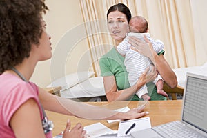 Doctor with laptop and woman in doctor's office