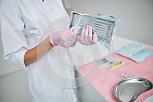 Doctor in latex gloves holding a surgical instrument