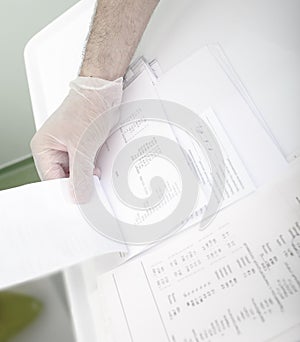 Doctor leafing through blood tests of the patient