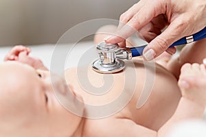 Doctor listening heartbeat of newborn baby by stethoscope