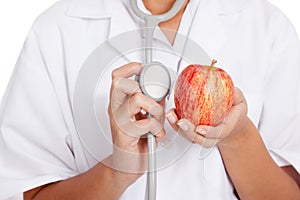 Doctor listening to an apple with a stethoscope