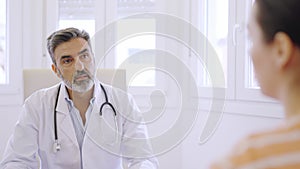 Doctor listening to a female patient in a clinic