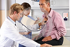 Doctor Listening To Male Patient's Chest