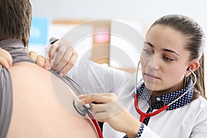 Doctor listening to patient back with stethoscope