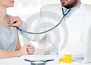 Doctor listening to patient chest with stethoscope. Checking heart beat of patient