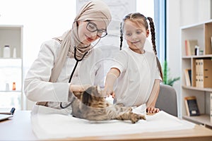 Doctor listening to pets lungs with stethoscope near child
