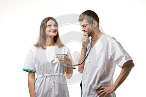 The doctor listens with interest to the girl`s heart with a phonendoscope