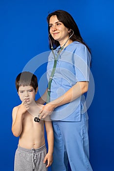 The doctor listens to the heart and lungs of a 5-year-old boy with a stethoscope.