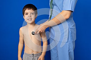 The doctor listens to the heart and lungs of a 5-year-old boy with a stethoscope.