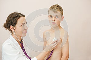 Doctor listens to lungs of boy with stethoscope