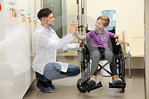 Doctor and little child in wheelchair