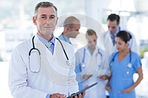 Doctor looking at camera while his colleague discussing