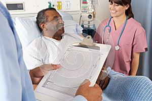 Doctor Looking At Chart With Senior Male Patient