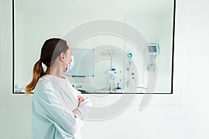 Doctor looking through hospital glass in ICU