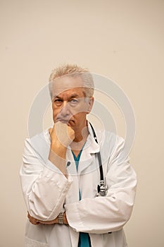 Doctor looking puzzled at camera with hand under chin