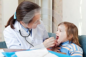 Doctor looks mouth of child