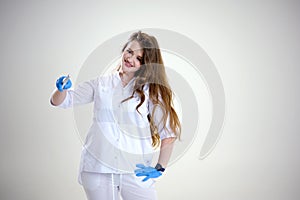 doctor with a magic wand in blue latex gloves loose hair conjures up a treatment. invents treatments advertisements for photo