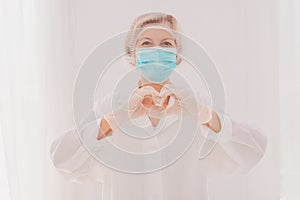 Doctor with mask makes a heart with her hands photo