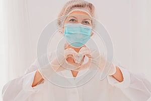 Doctor with mask makes a heart with her hands photo