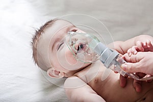 Doctor makes inhalation to a sick little baby.