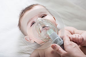 Doctor makes inhalation to a sick little baby.