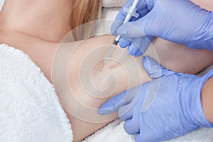 The doctor makes intramuscular injections of botulinum toxin in the underarm area