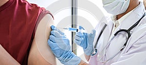 Doctor making a vaccination into patient with needle getting immune vaccine at arm for flu shot, coronavirus protective of