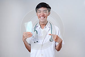 Doctor male smiling holding medical face mask