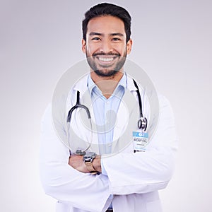 Doctor, man with arms crossed and happy in portrait, health and medical professional on studio background. Male