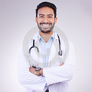 Doctor, man with arms crossed in portrait and smile, health and medical professional on studio background. Male