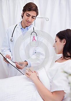 Doctor man with breast cancer awareness ribbon with patient