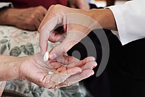 Doctor man giving some pills to a senior woman