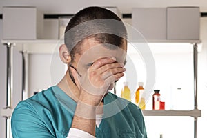 Doctor man in medical apparel facepalm crying ashamed.