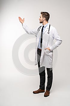 Doctor man, medical professional presenting something isolated over white background.