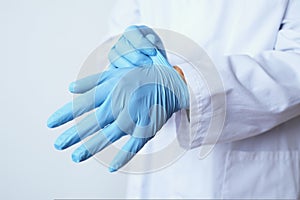 Doctor man putting on surgical gloves