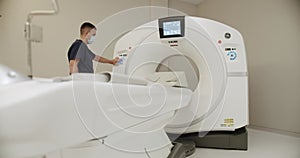 Doctor man radiologist turn on MRI or CT machine in hospital