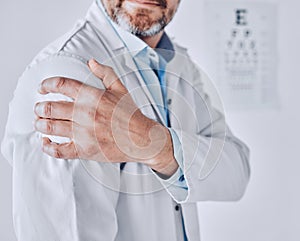 Doctor man, shoulder pain and hand with stress injury, fatigue and burnout at optometry job in clinic. Ophthalmologist
