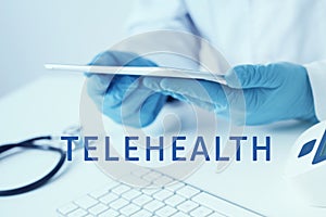 Doctor man using a tablet and text telehealth photo