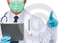 Doctor man in white coat with protection mask holding tablet and pointing something isolated and white background with clipping