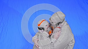 Doctor man and woman in protective costume suit, gas protect medical spray paint mask. Love couple kiss and hug, health